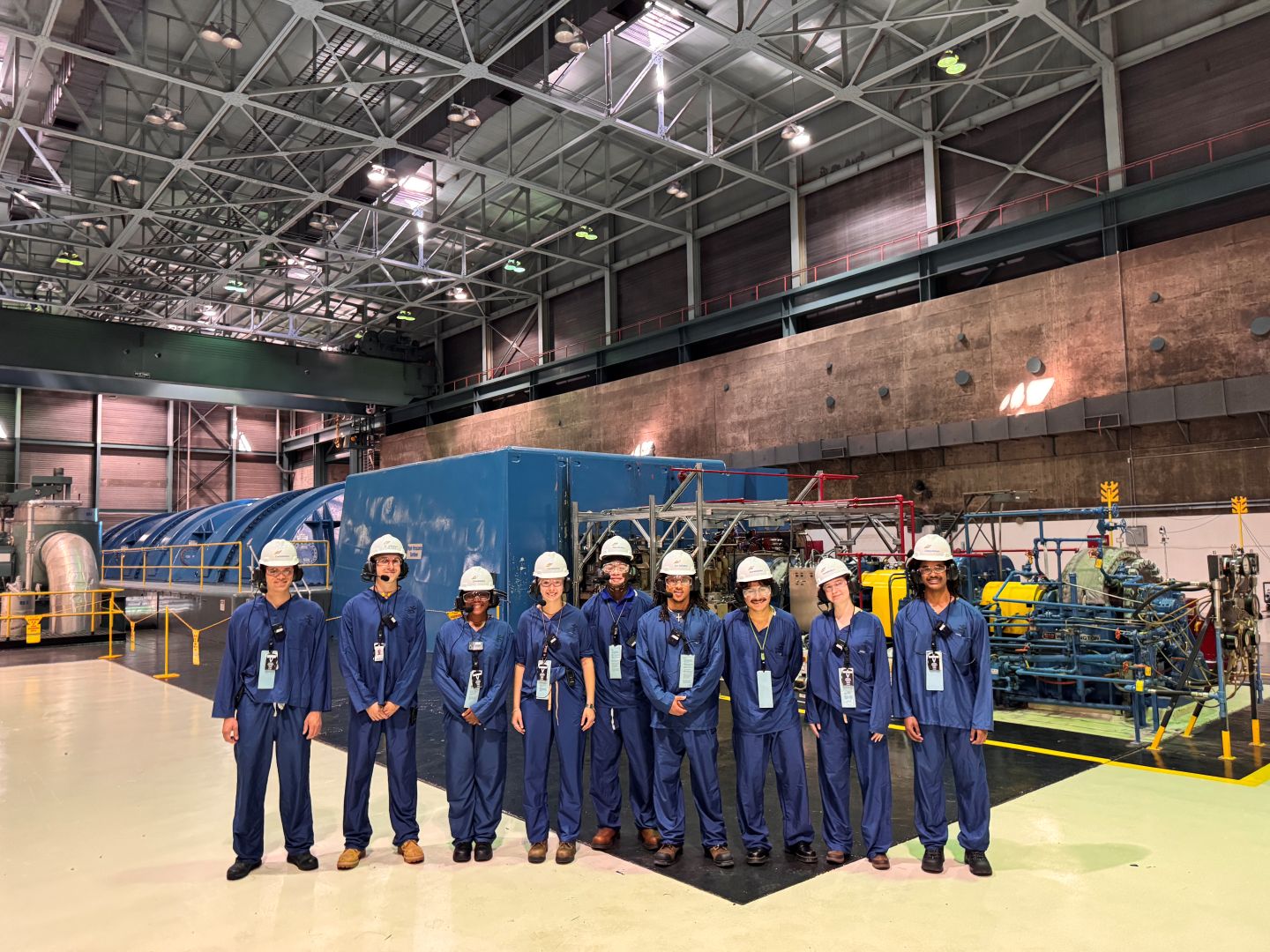 People in blue uniform and white hard hats standing in a group.