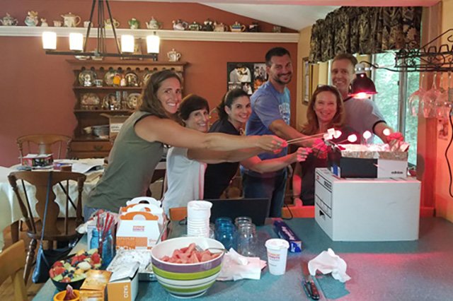 Institute for STEM Education Six smiling people roasting marshmallows in a kitchen