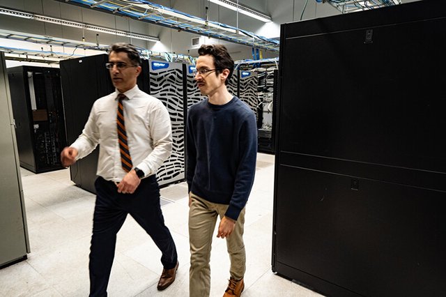 Two professors standing in laboratory with generators