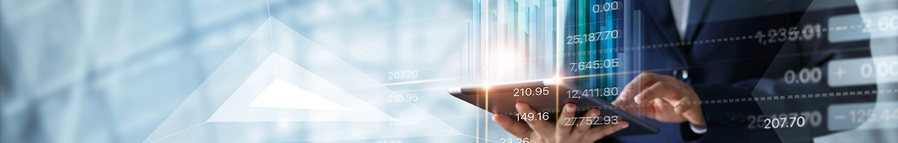 A person in a suit uses a tablet with bar charts and financial data overlays