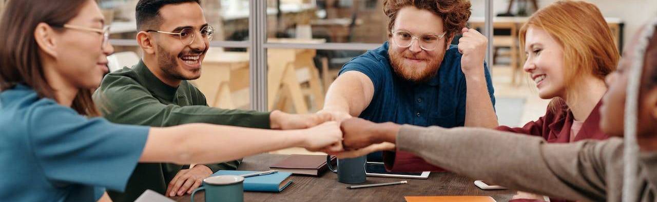 Students fist bumping over a table