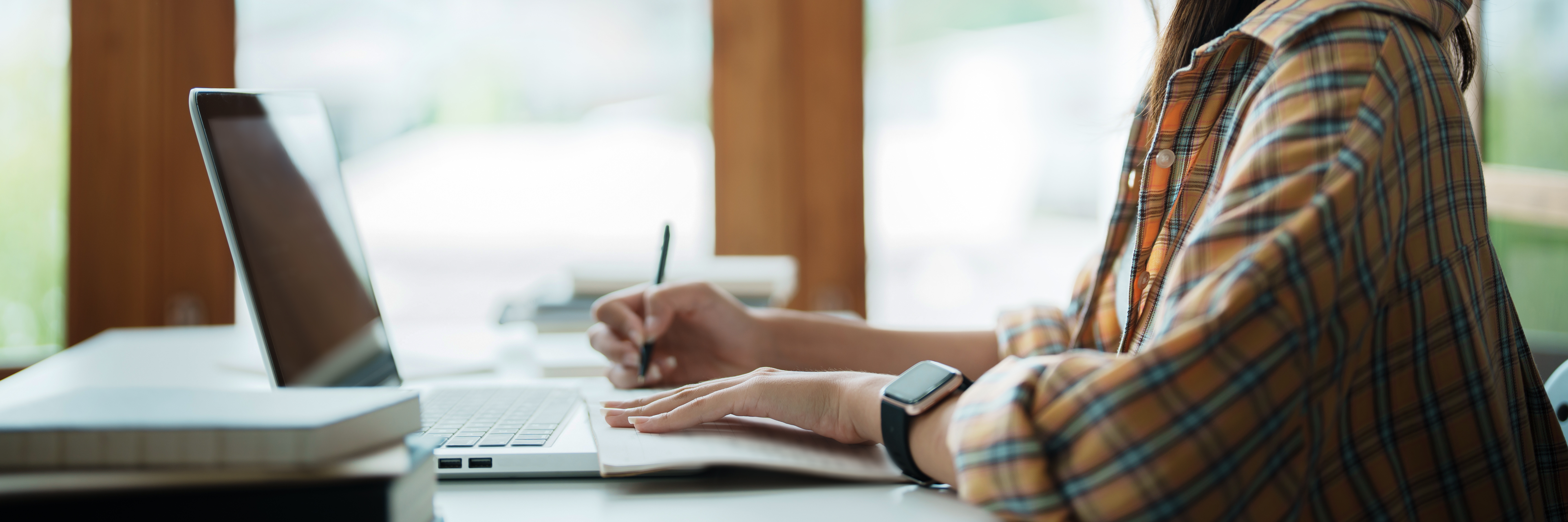 A student working on coursework on her computer.