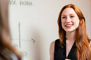 woman standing in front of wipe board