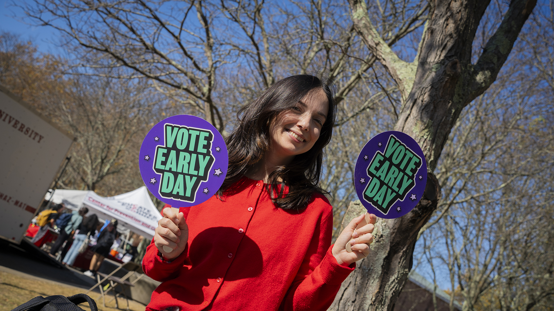 Ashley Liegi holding up Vote Early Day signs.
