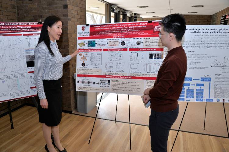 Xiumei Jian presenting a technical poster on biochar and wastewater treatment to a Fanjian Zeng.