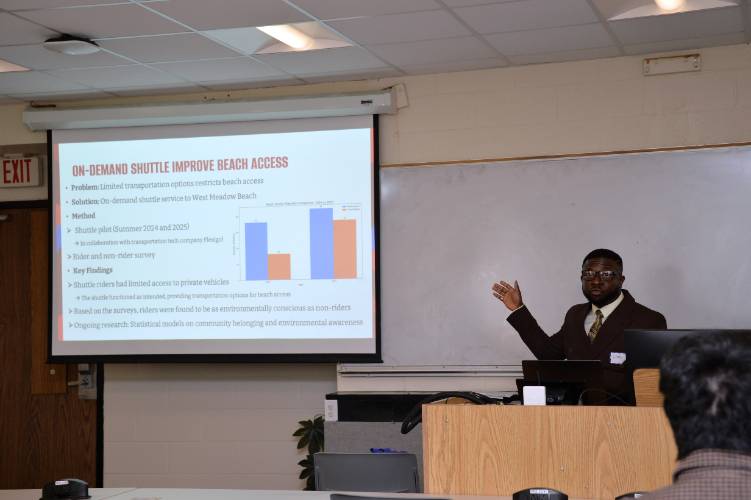 Samuel Osei Poku presenting research on an on-demand shuttle pilot program for beach access in a classroom setting.