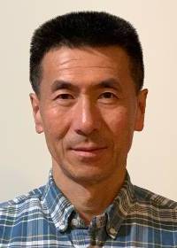 Headshot of Jin Wang standing against a white background