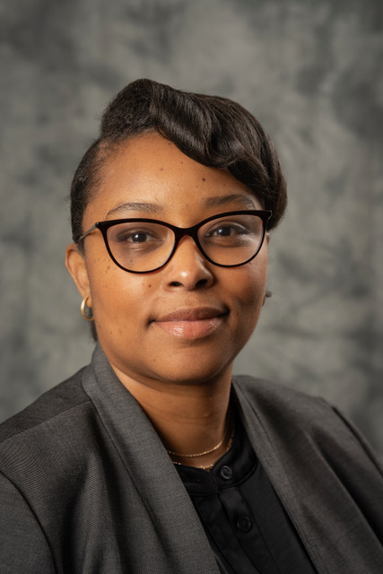 Bonita London in professional wear and glasses smiling