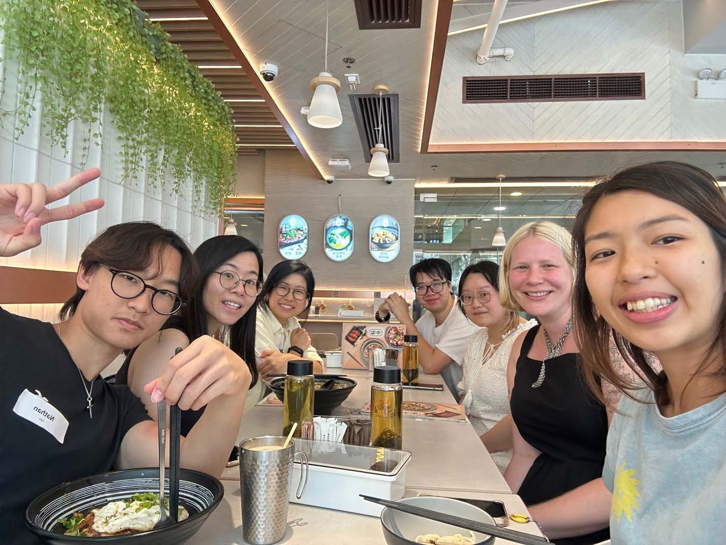 Hong Kong Restaurant Group of people enjoying a meal together at a restaurant, smiling and making peace signs.