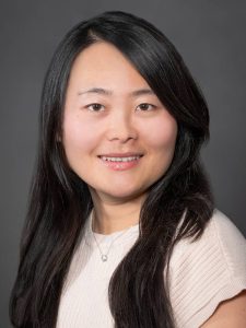Female with long black hair wears a white shirt