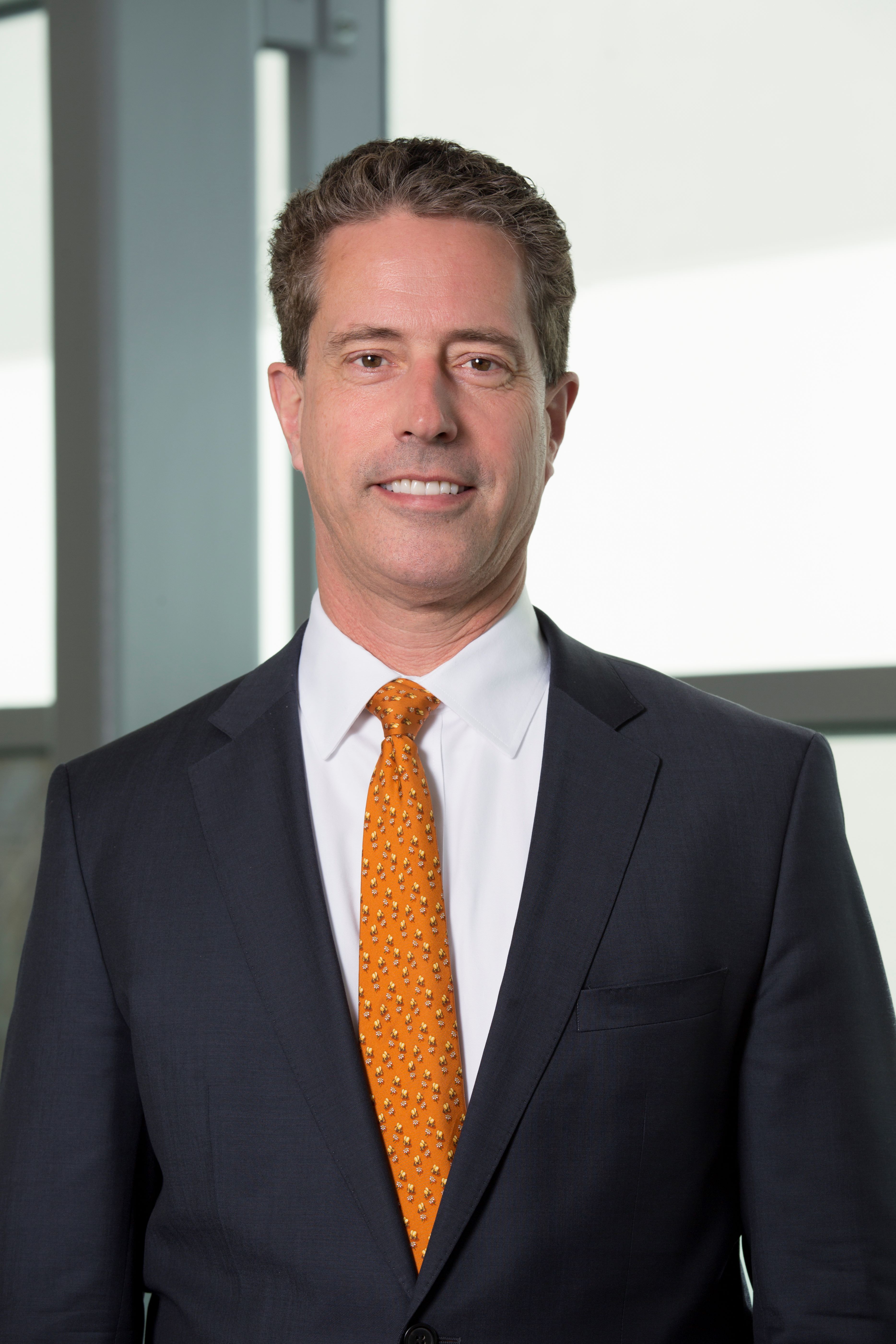Male posing with a suit and gold tie