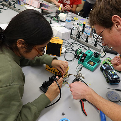 Students working wtih tools to adapt a toy.
