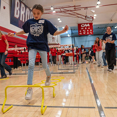 A young girl jumps at a sports event.