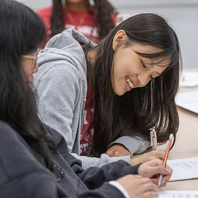 A student writes notes on a piece of paper.