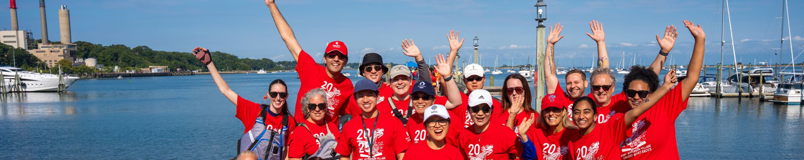 Group photo of Stony Brook students and staff at an event overlooking Port Jefferson Harbor