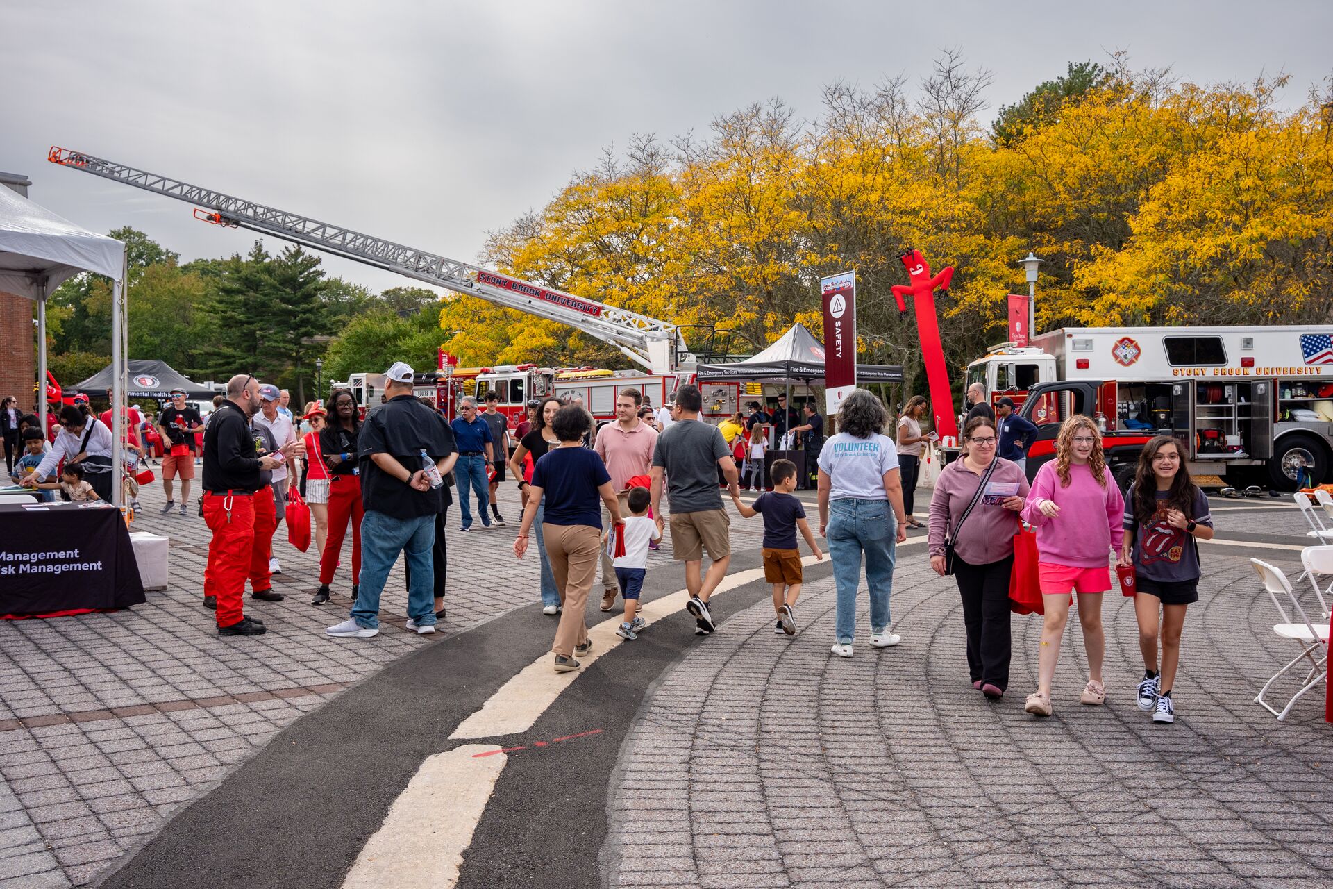 Attendees explore safety and emergency vehicles at a festival.