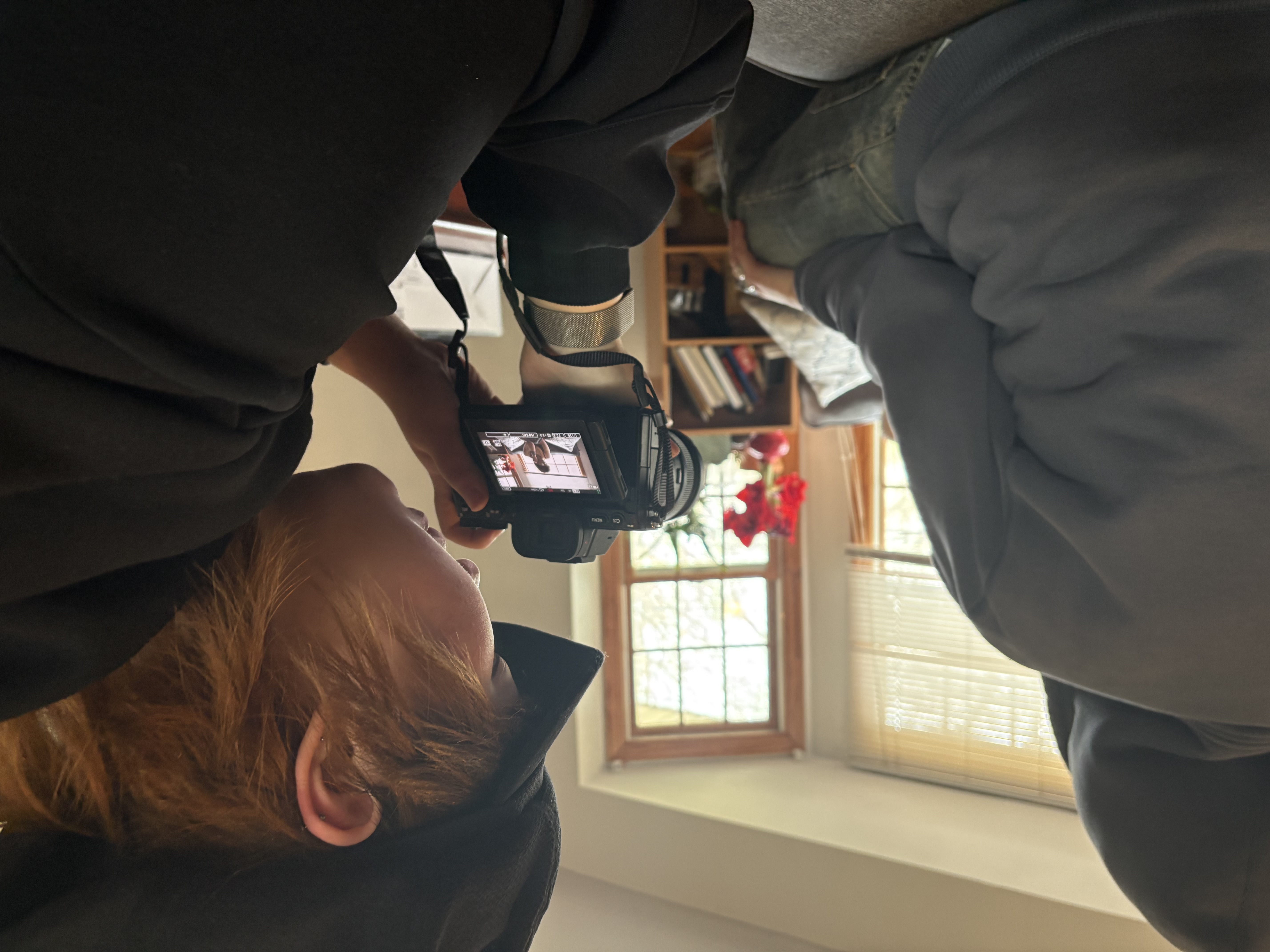 student holding camera filming