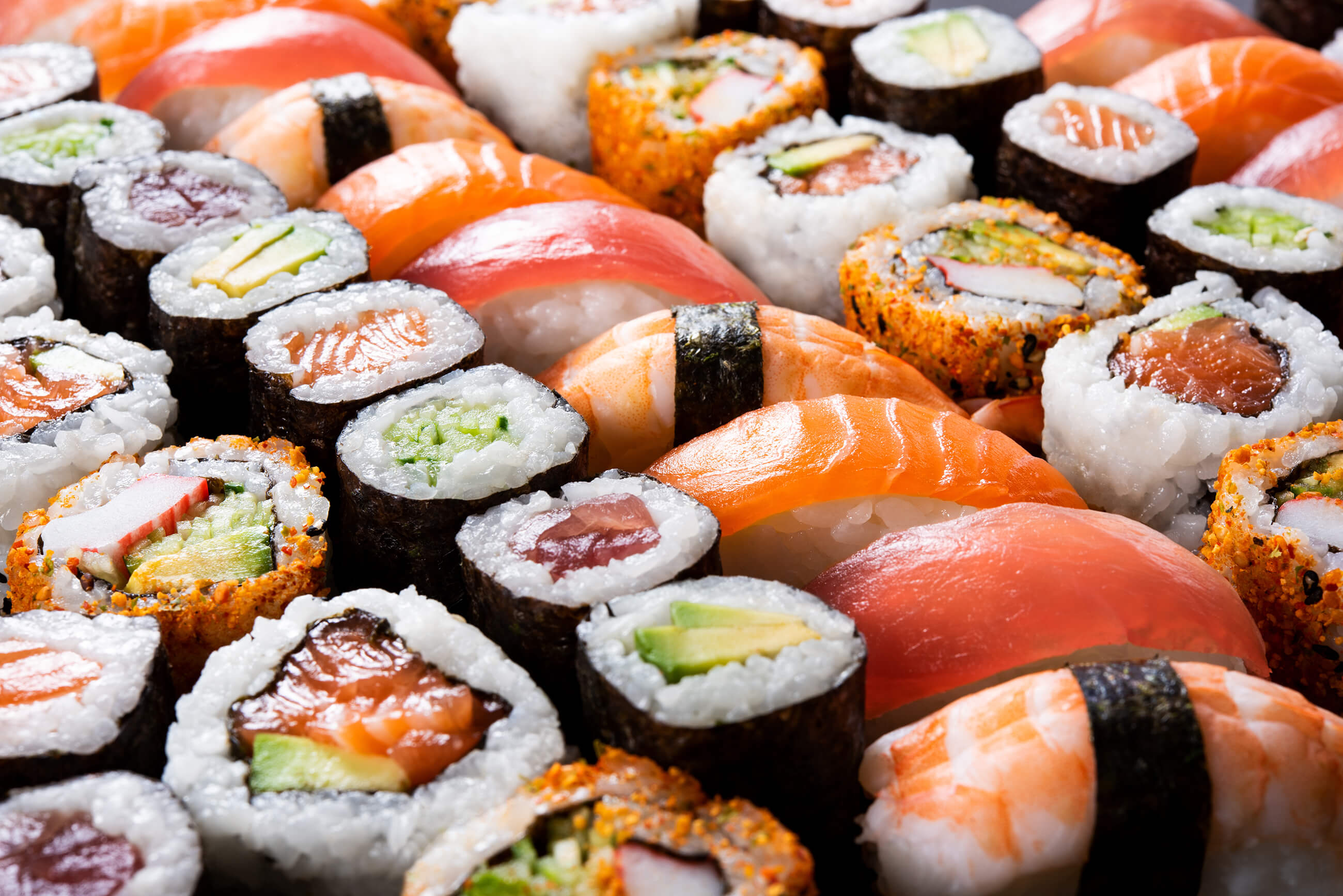 Assorted sushi rolls and nigiri with colorful fish and vegetables