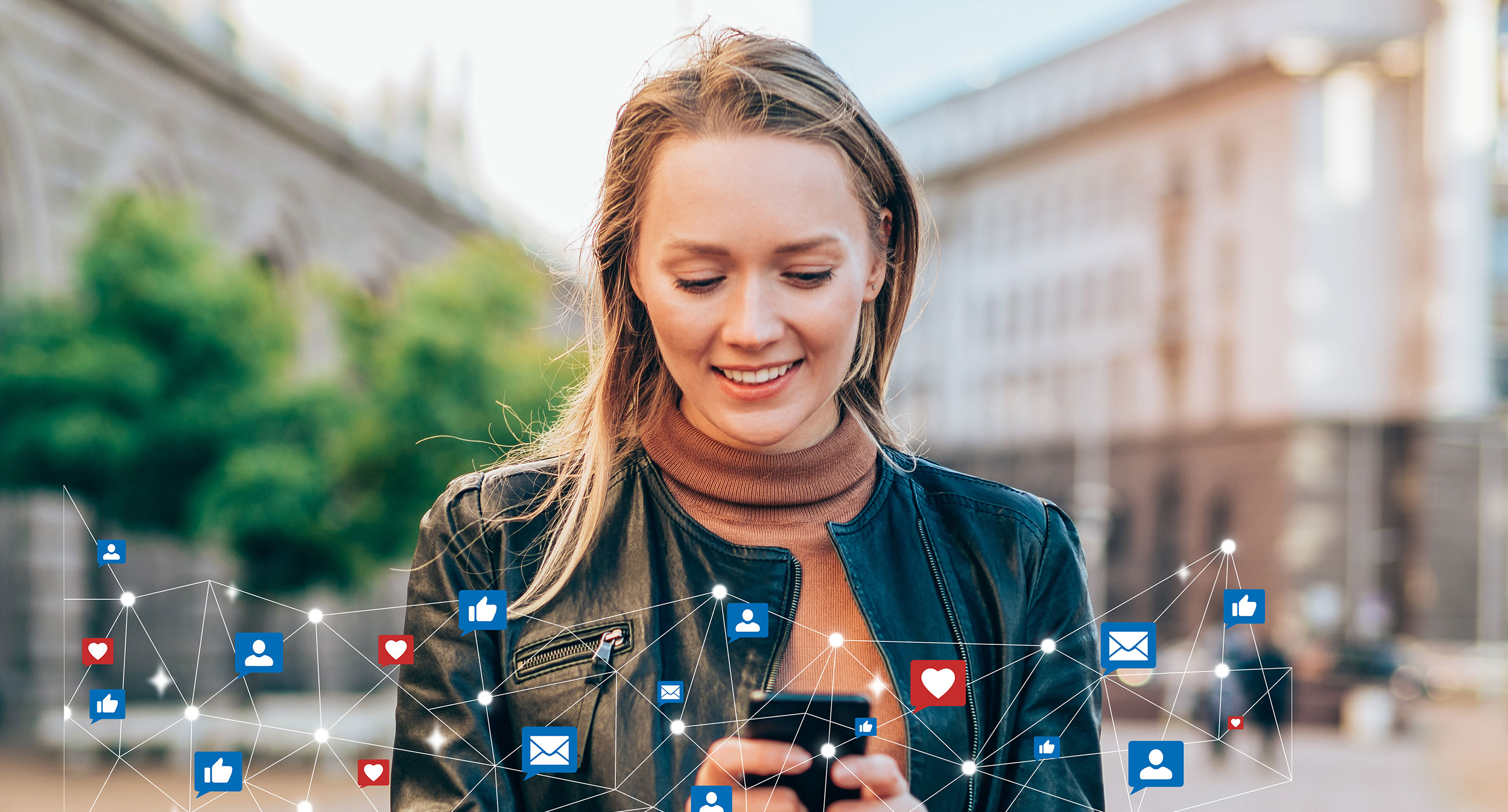 A smiling young woman in a black leather jacket and brown sweater is looking at her smartphone outdoors, surrounded by colorful social media icons representing connectivity.