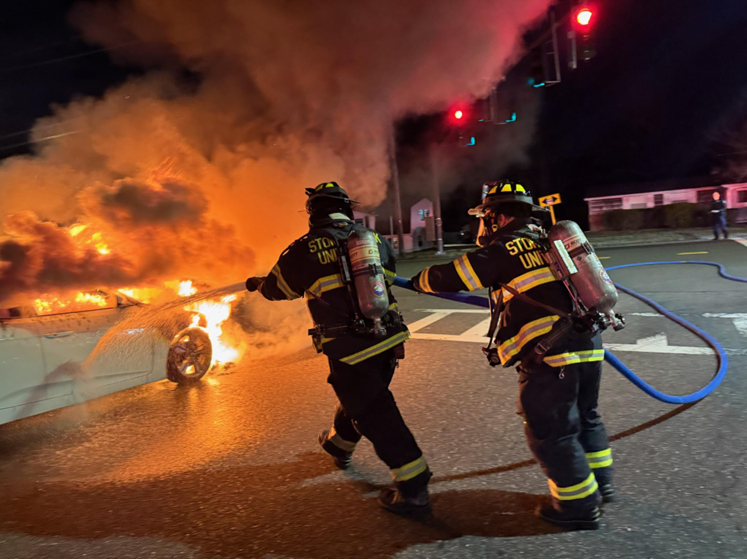 Firefighters putting out car fire