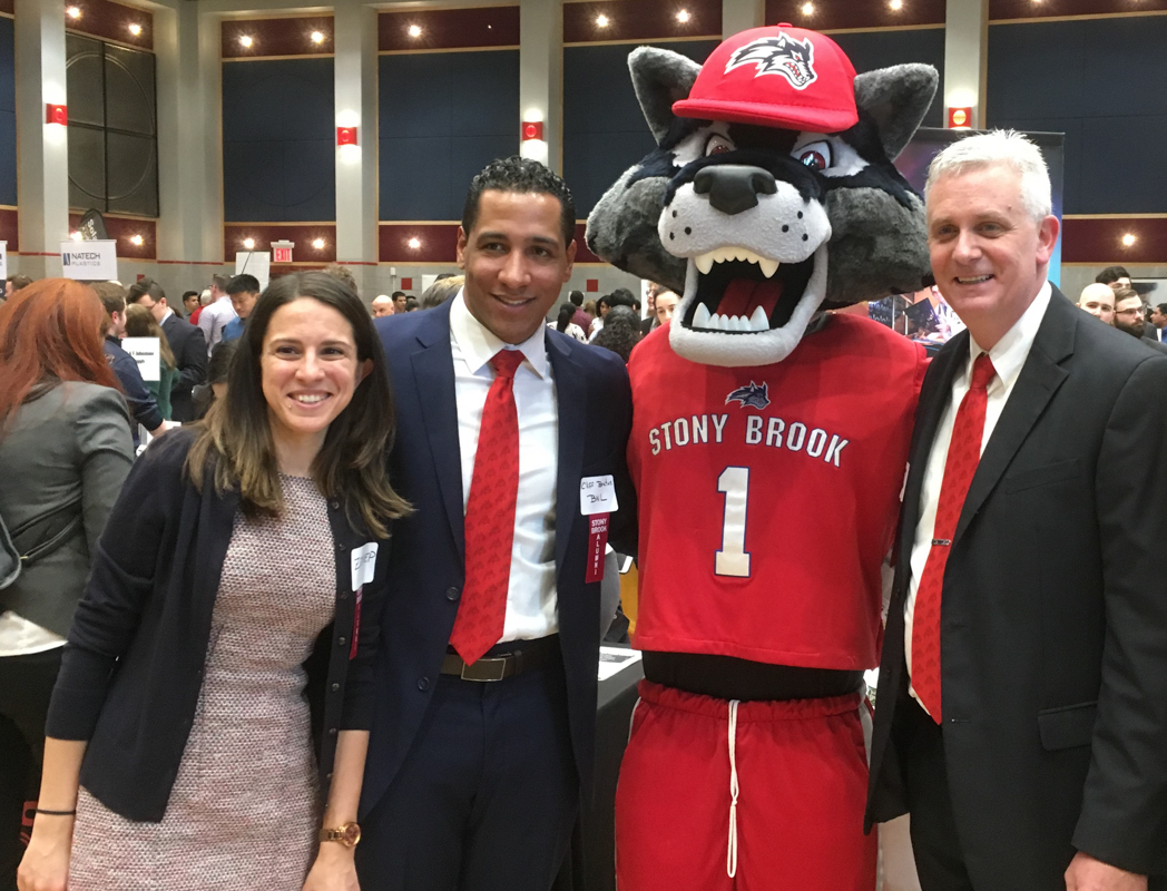 Three individuals standing with Stony Brook University mascot