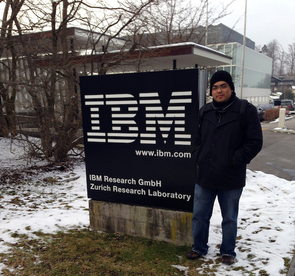 A guy standing next to the IBM sign in the winter.