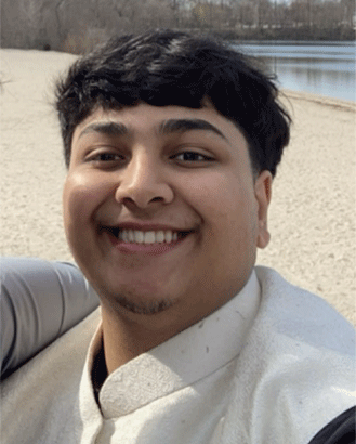 Ameem, an ECE undergraduate student, smiling for a photo in front of a blurred nature background.