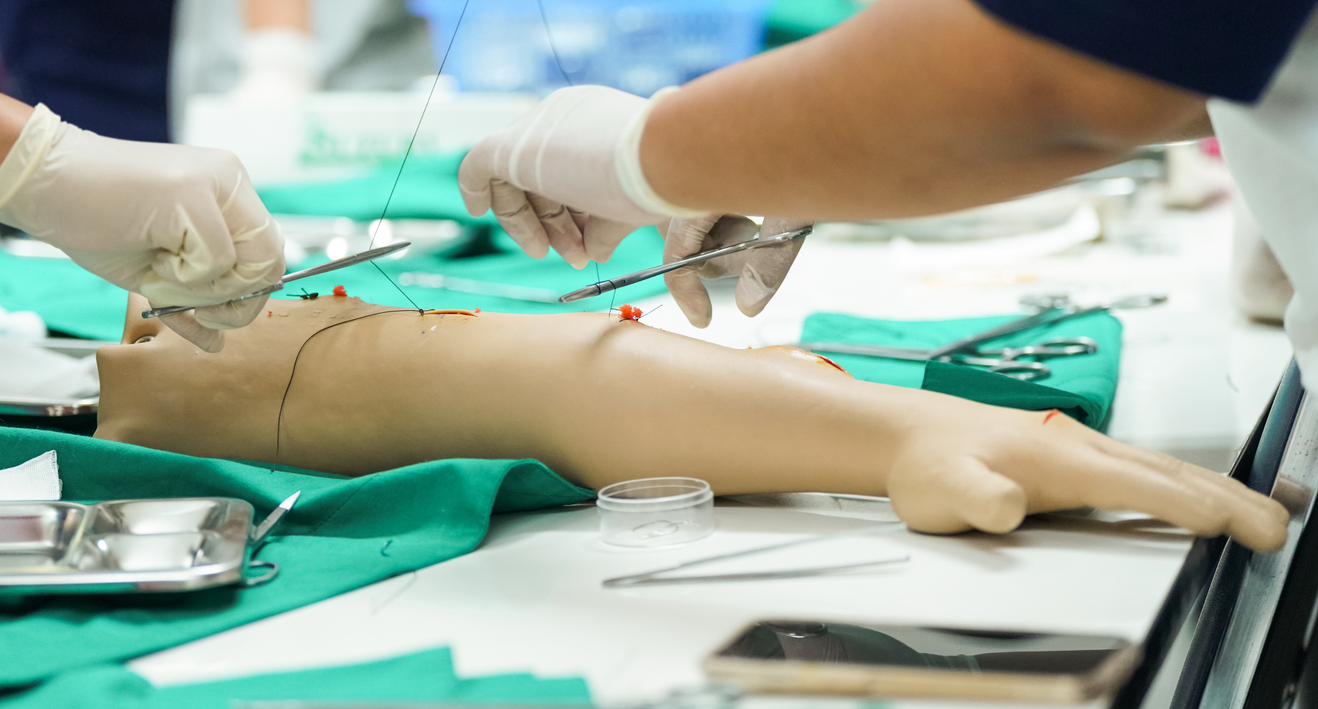 nursing student hands working on dummy arm