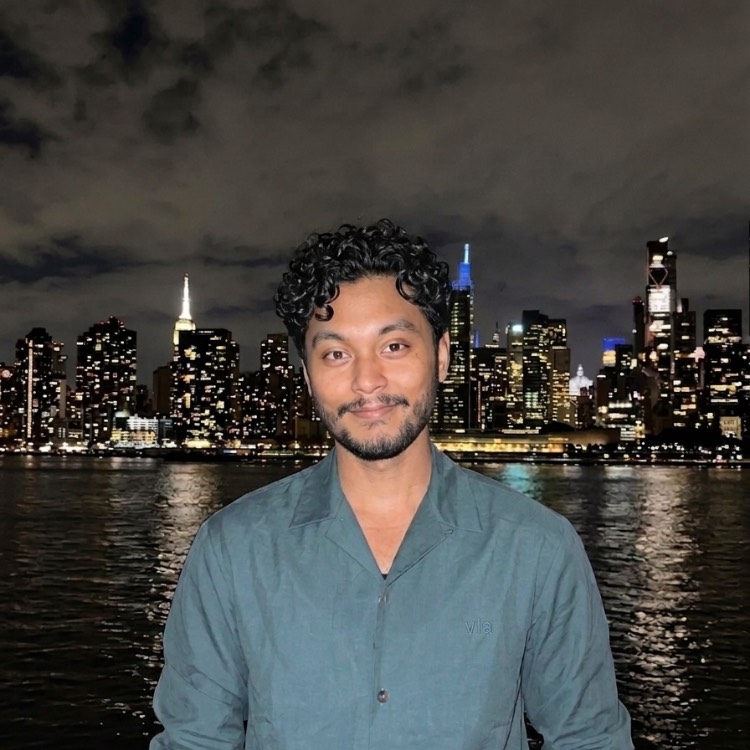 Mahim Hasan Boy in blue shirt standing in front of the NY City skyline at night