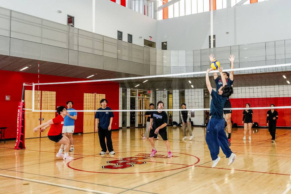 Students playing a game of volleyball in the Rec Center gym.