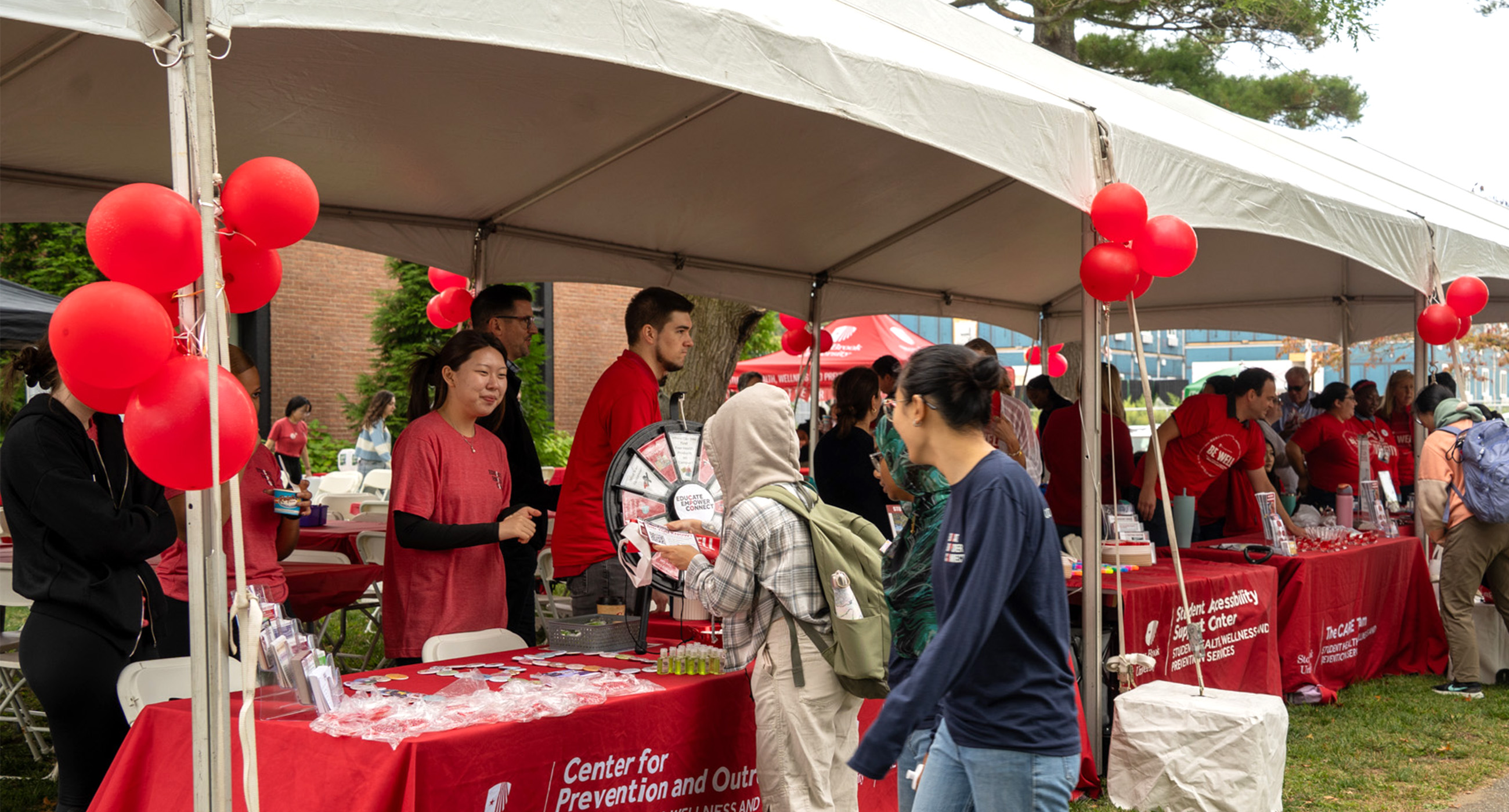 Students at a table outside during Be Well Fest.