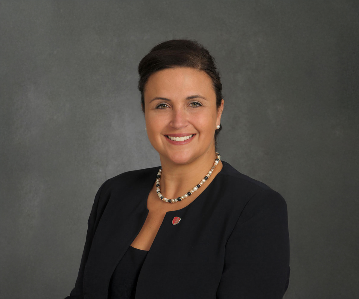 Dr. Marisa Bisiani wearing a black shirt, necklace, and SBU lapel pin.