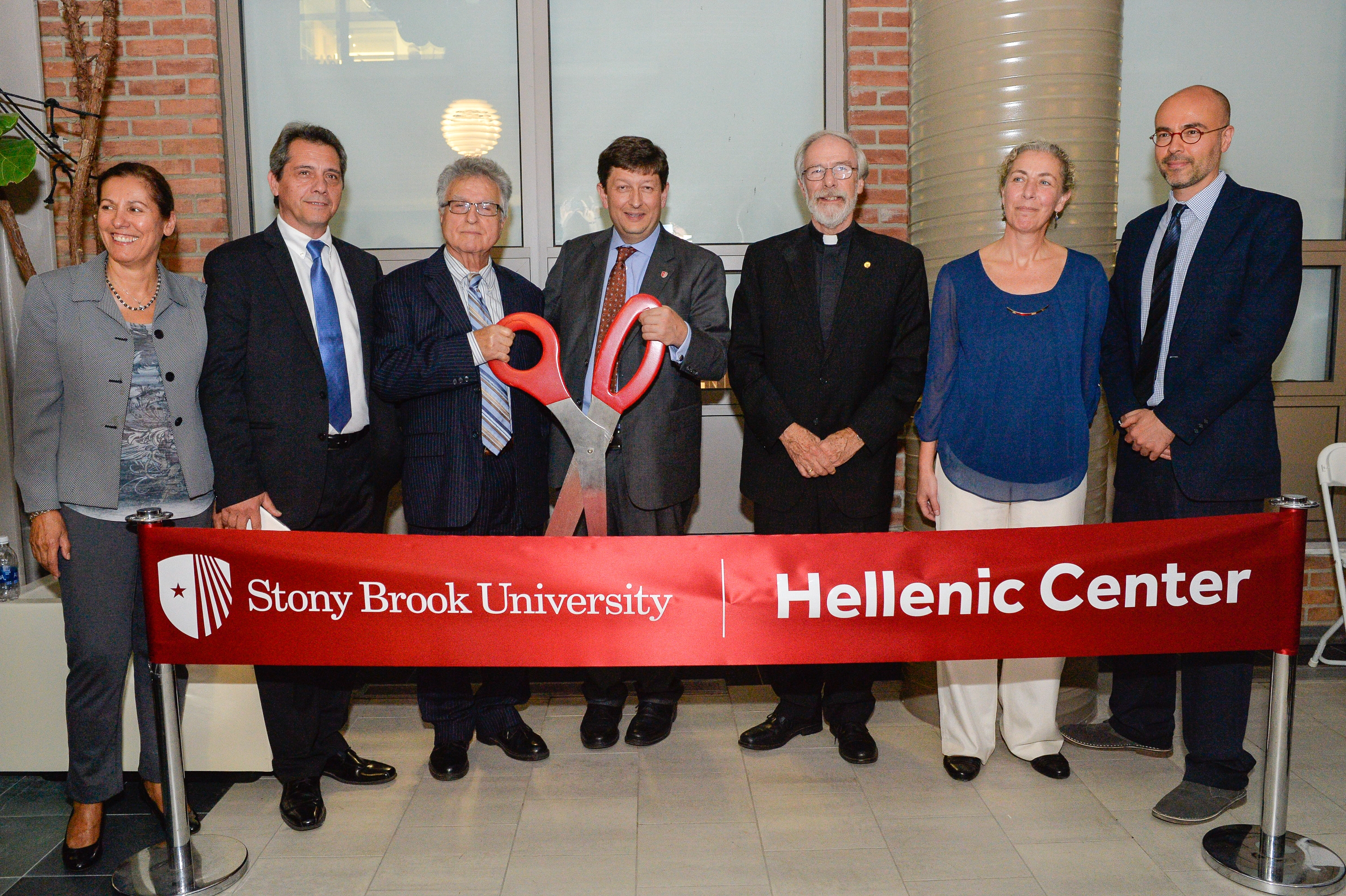 7 people infront of a ribbon that reads: "Stony Brook University Hellenic Center". Two people are holding ceremonial scissors.