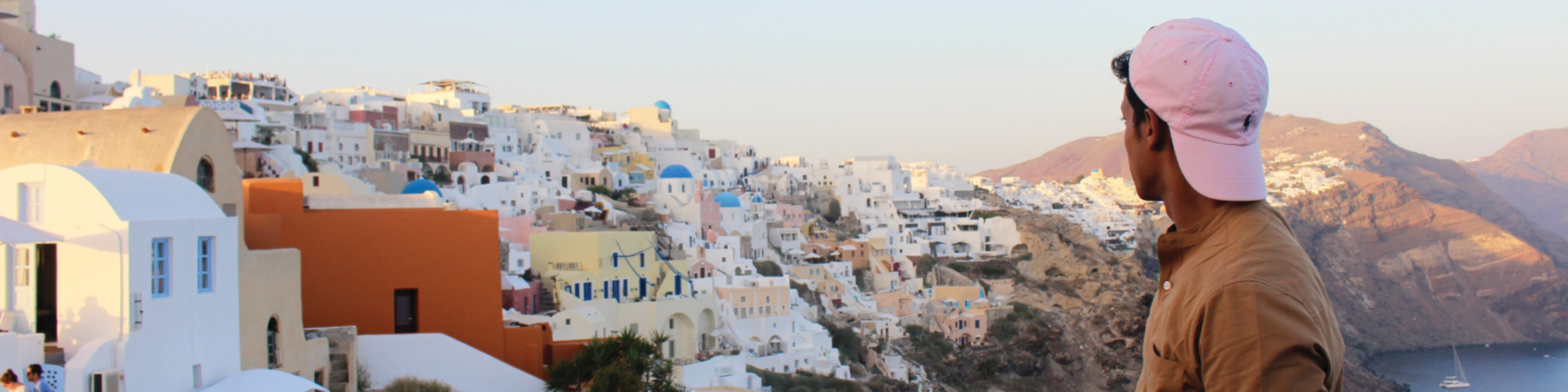 Person looking at a coastal Greek cityscape