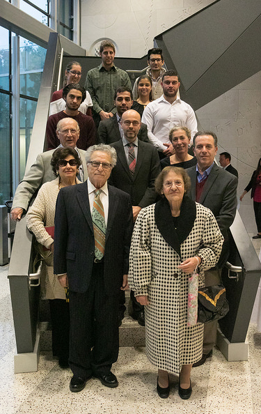 Tsantes and a group of former students pose on a staircase.