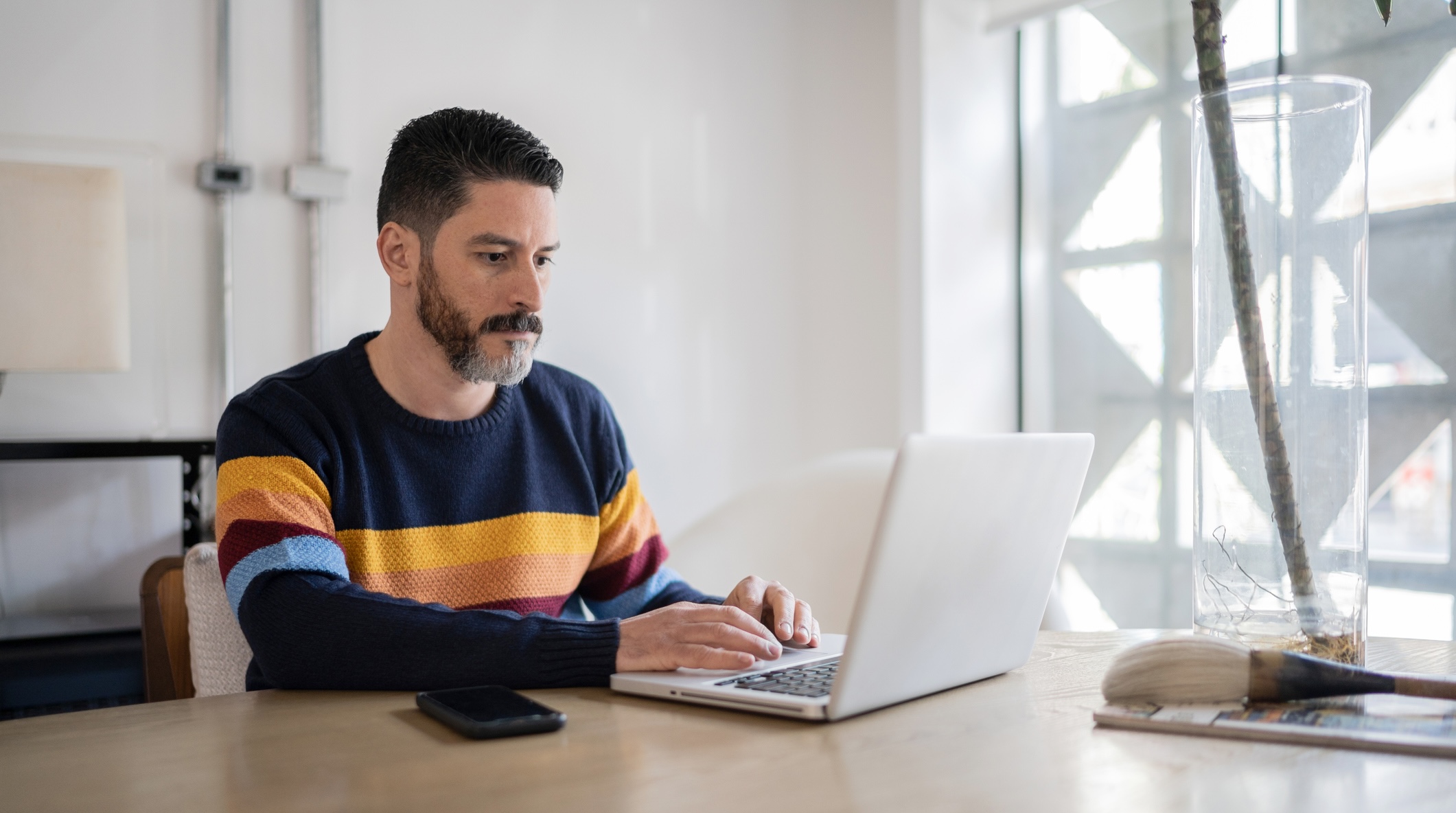 A part-time HEA master's student working on a project from his laptop