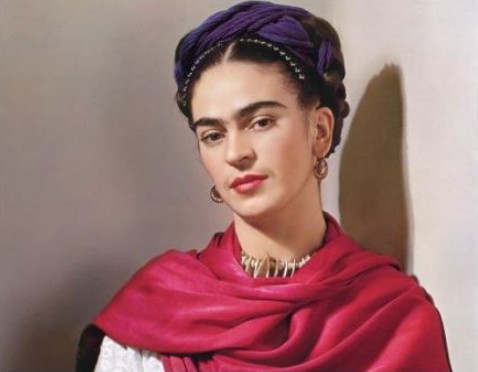 Mexican artist Frida Kahlo with her signature unibrow, braided hair, and a magenta shawl.