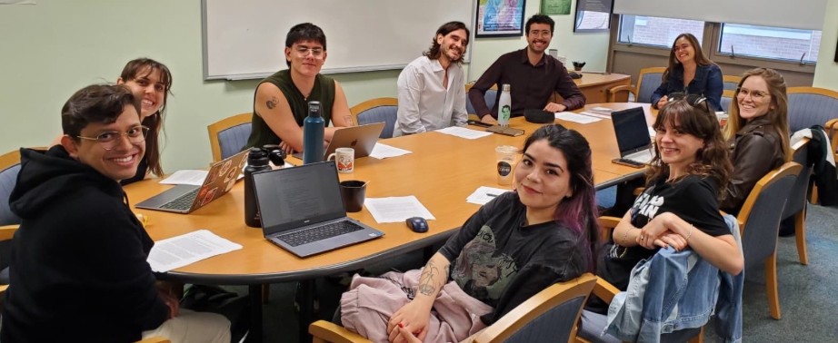 A group of students works together around a large table in a classroom.