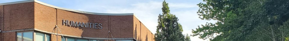Exterior view of the brick Humanities building with surrounding trees.