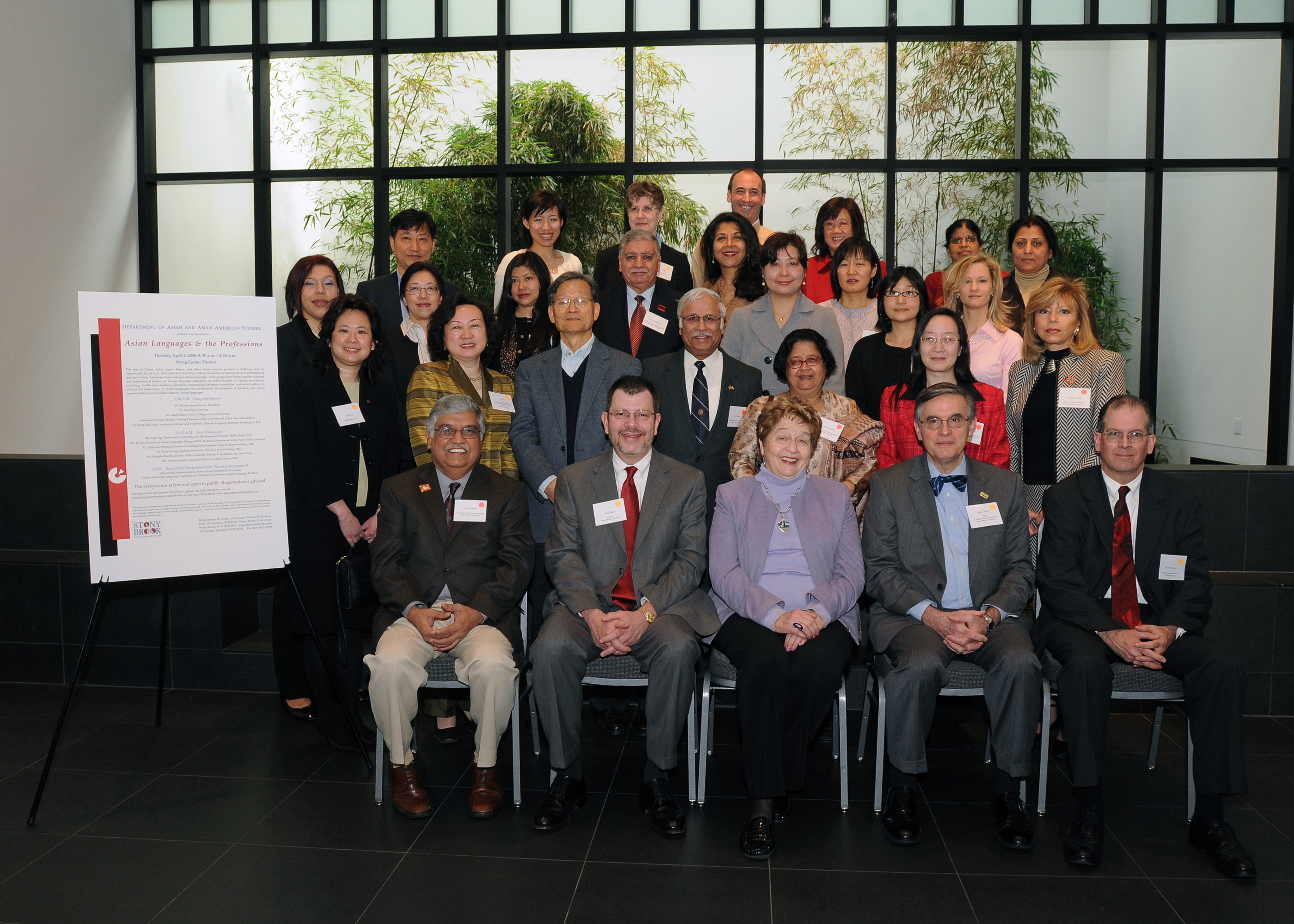 Four rows of people sitting and standing with name tags