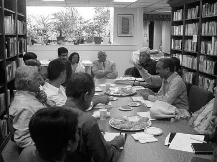 Black and white photo of people sitting at a conference table