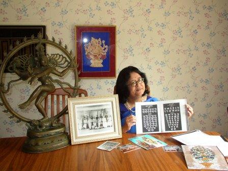 Woman sitting at a table holding picture frames