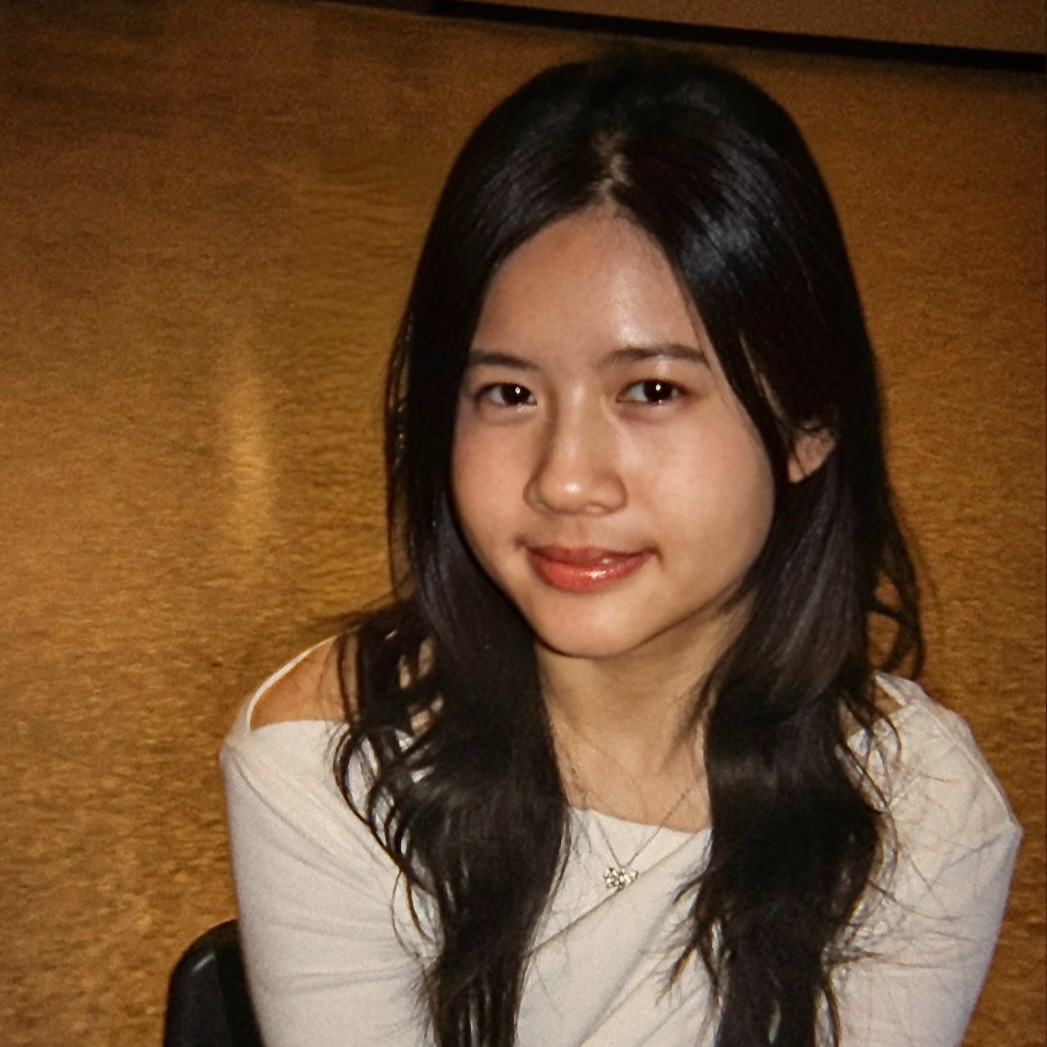 Girl with dark hair and white top smiles
