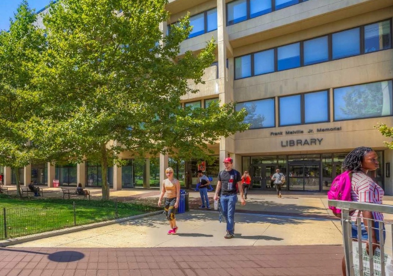 Students walking in front of the Frank Melville Jr. Memorial Library