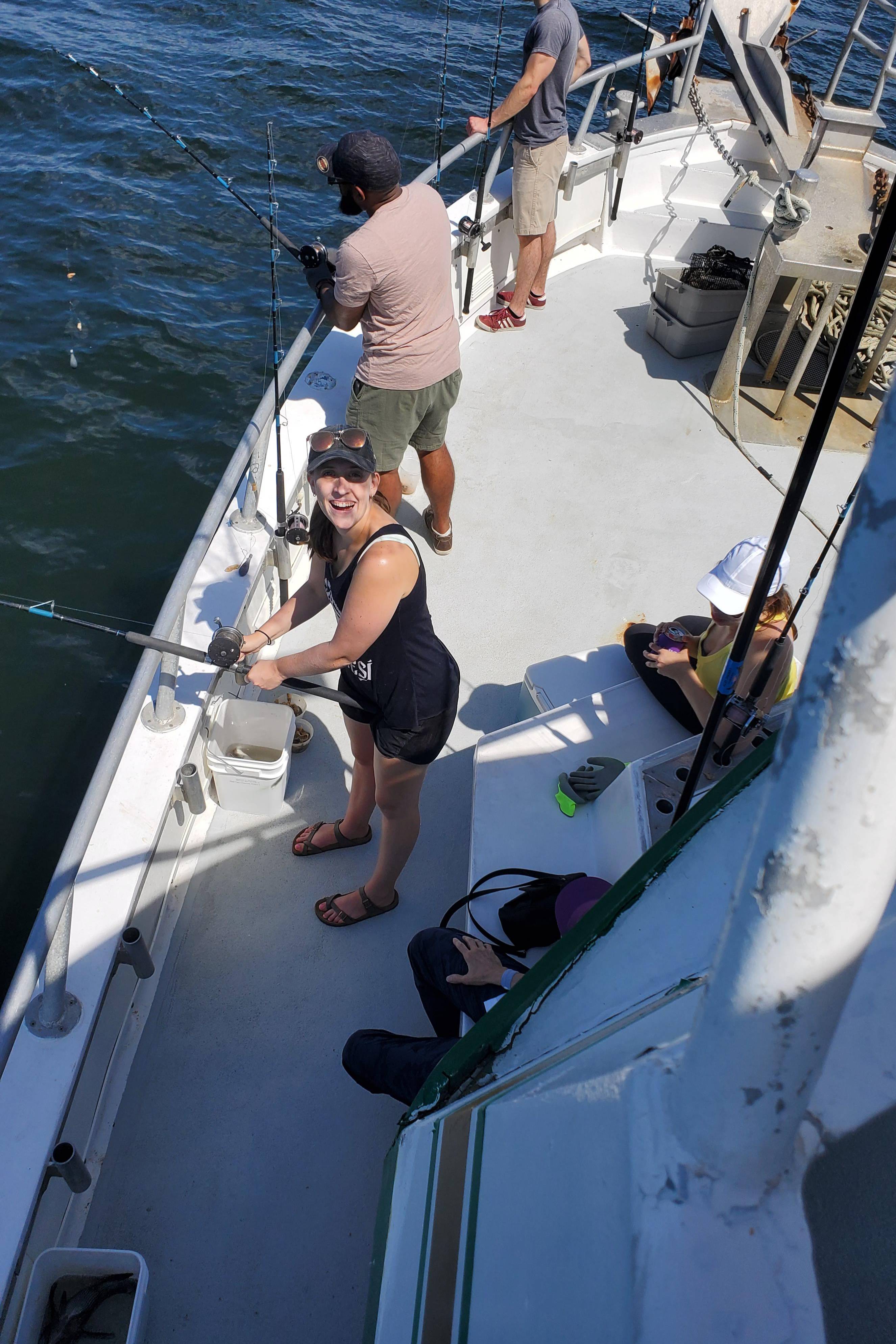People holding fishing rods on a boat