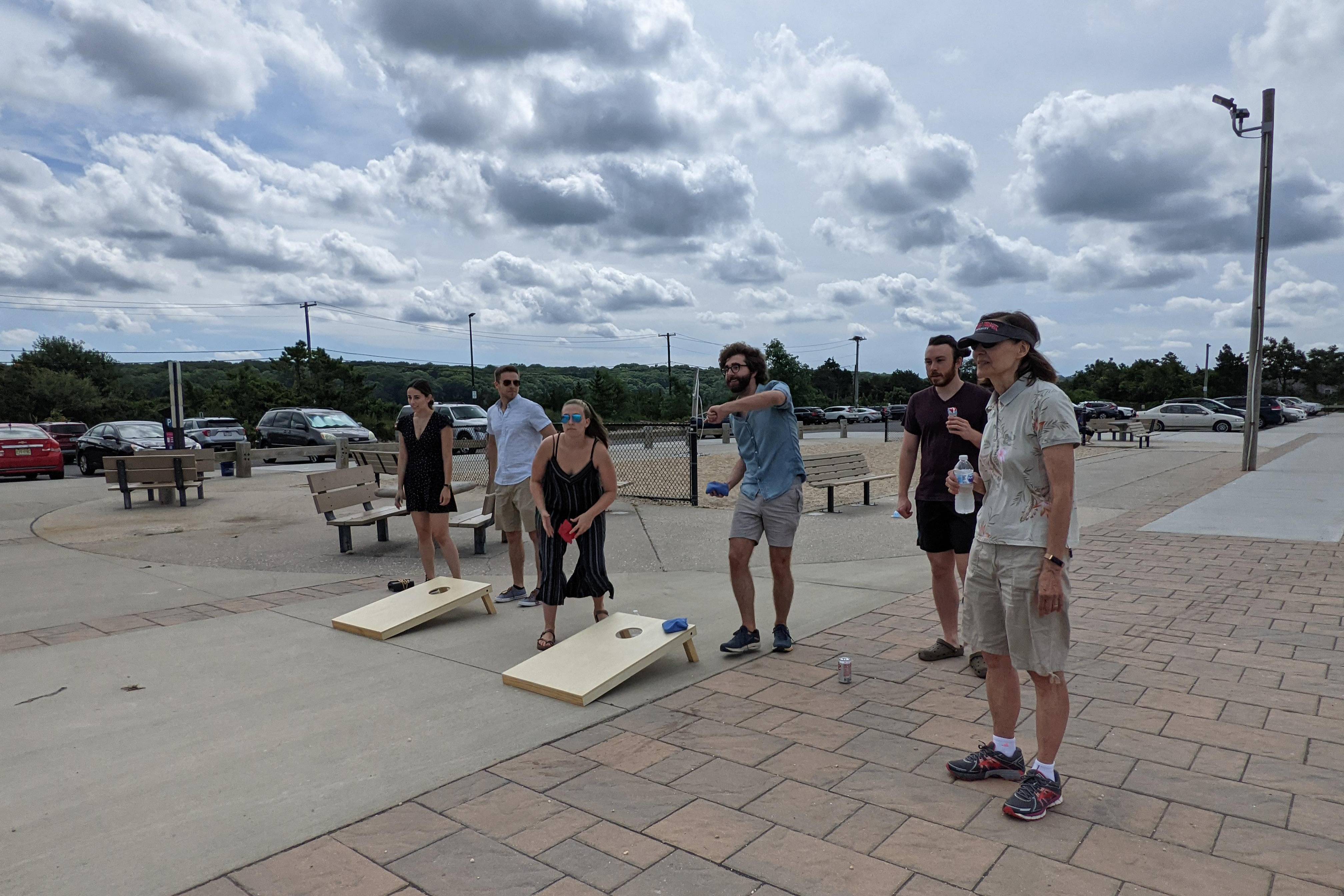 Group of people playing cornhole on the beach