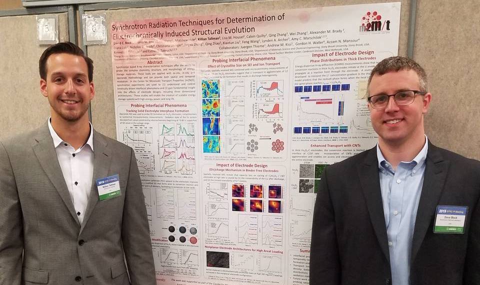 Two students in front of a poster