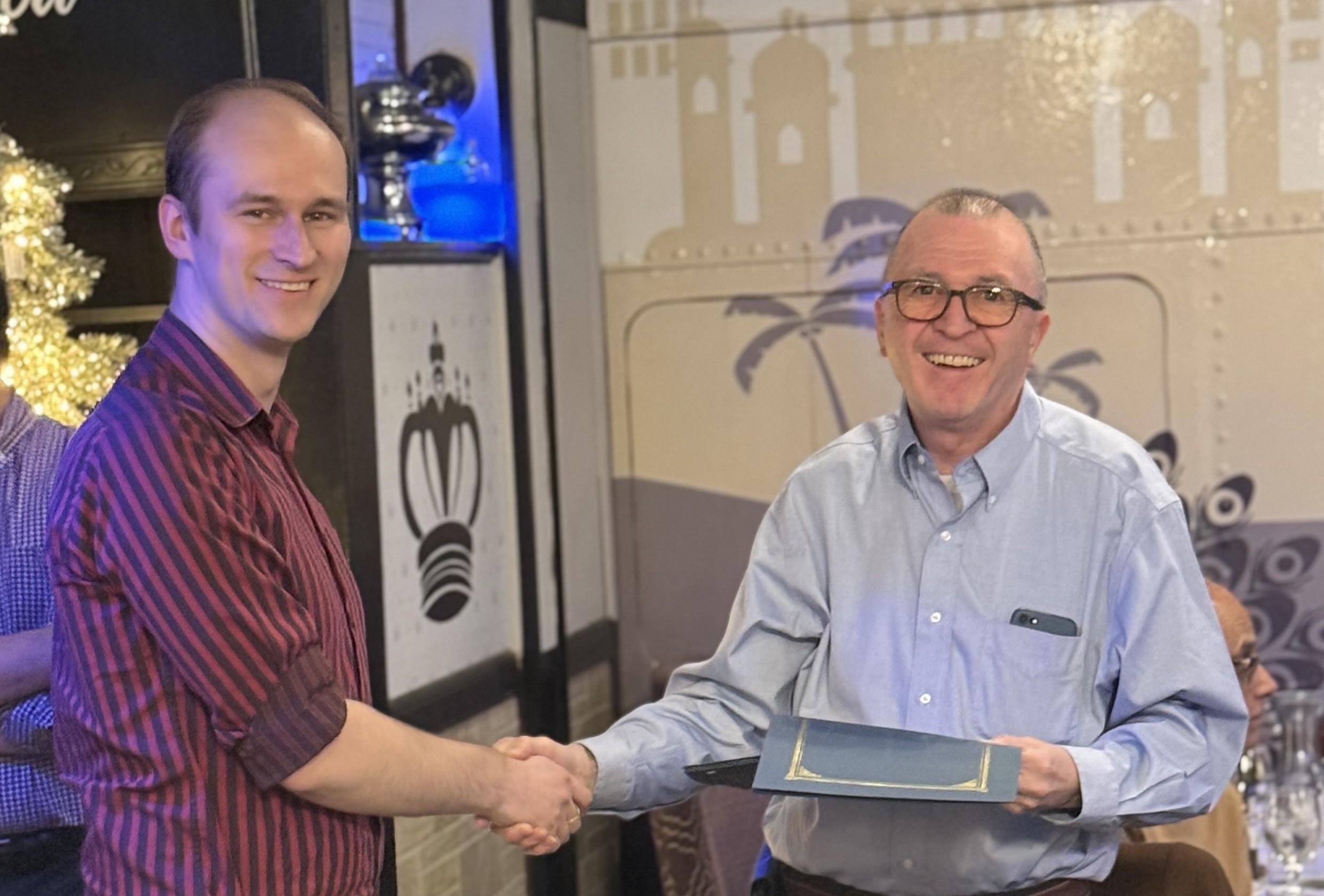 Two people shaking hands and smiling