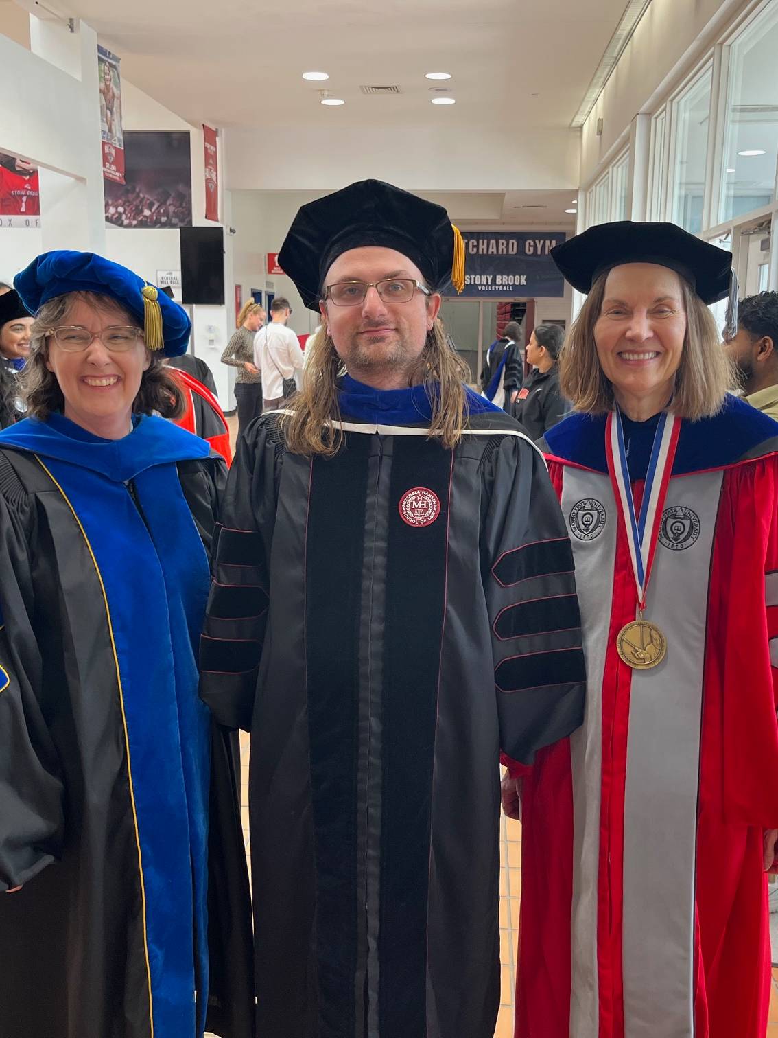 Three people in graduation gowns