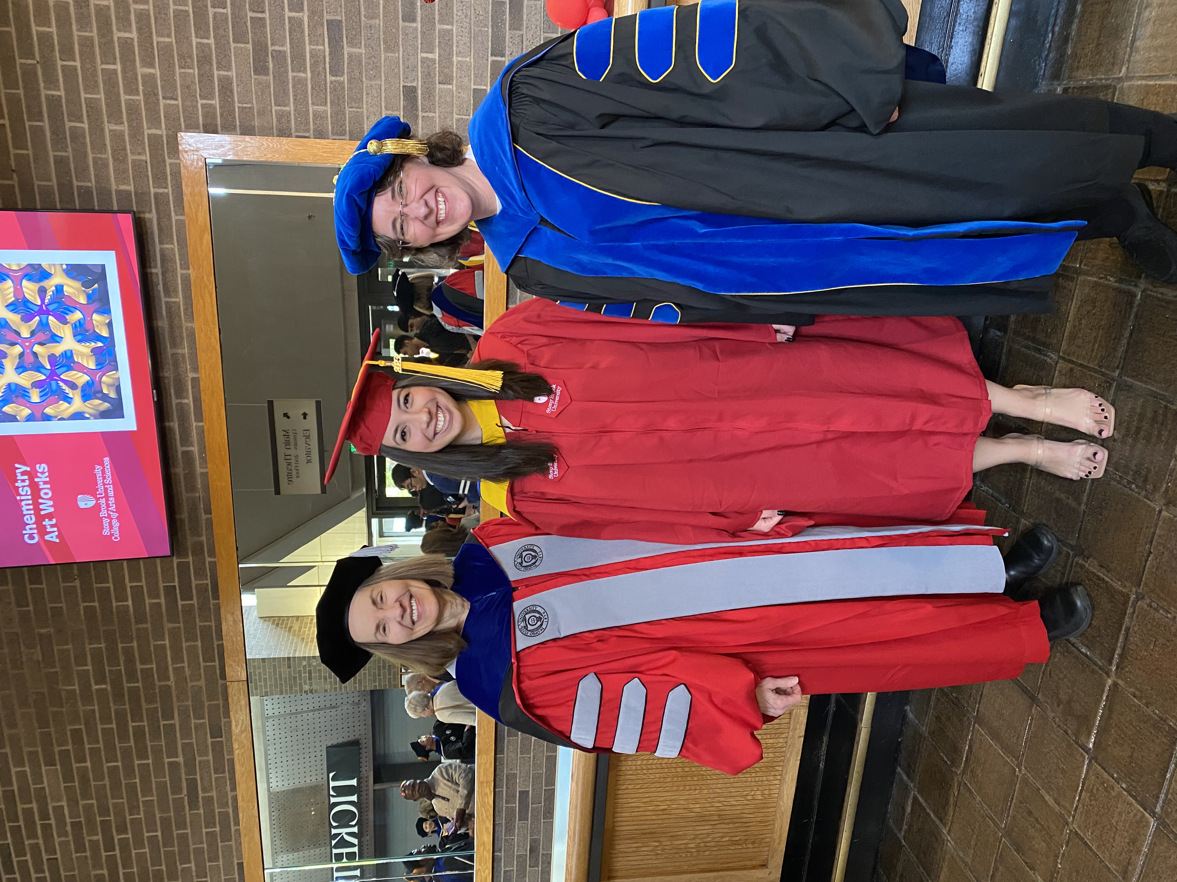 Three people in graduation gowns